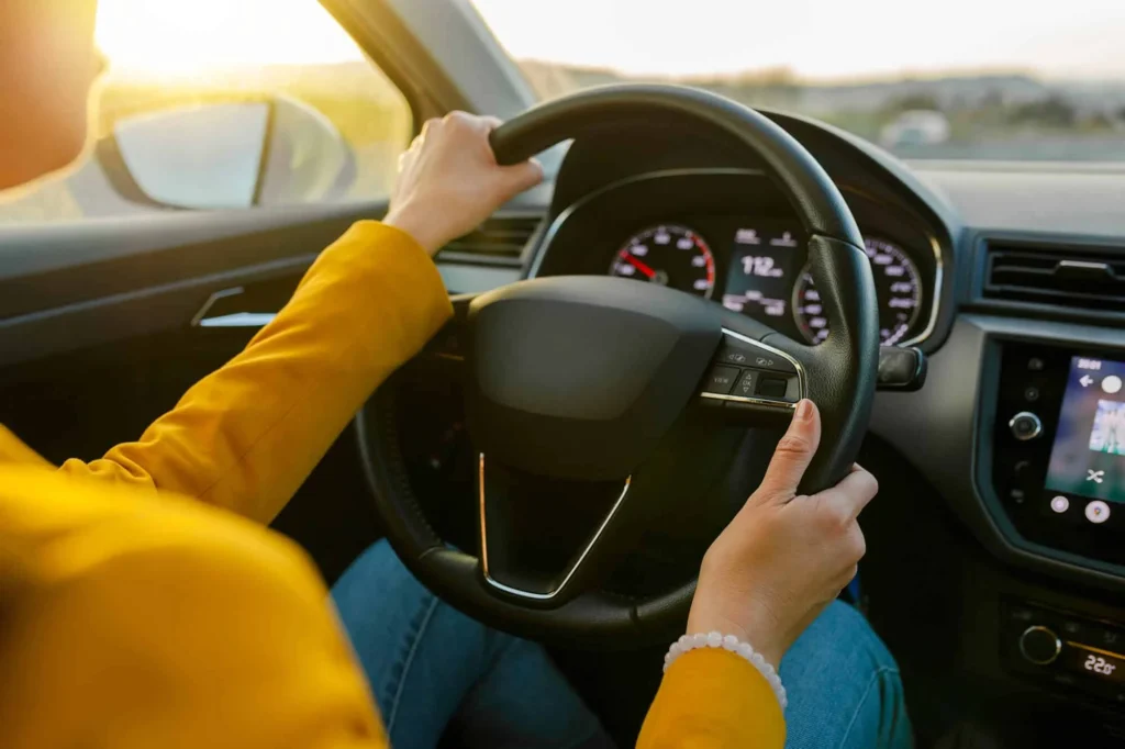 Mains d’une élève sur le volant pendant une leçon de conduite