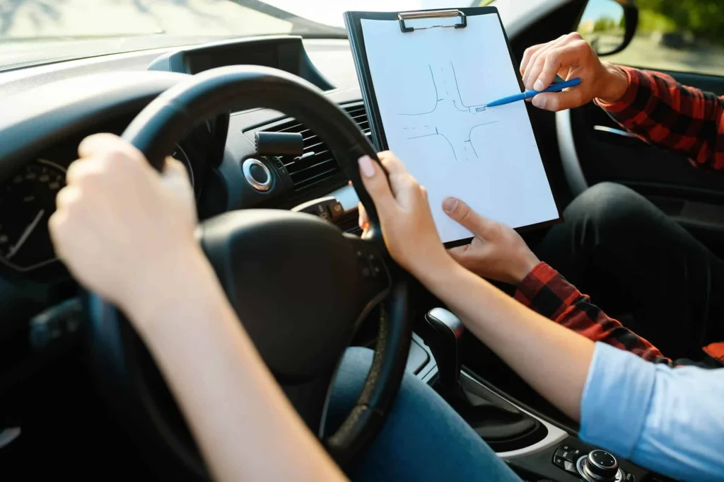 Moniteur et élève remplissant le livret d’apprentissage dans la voiture