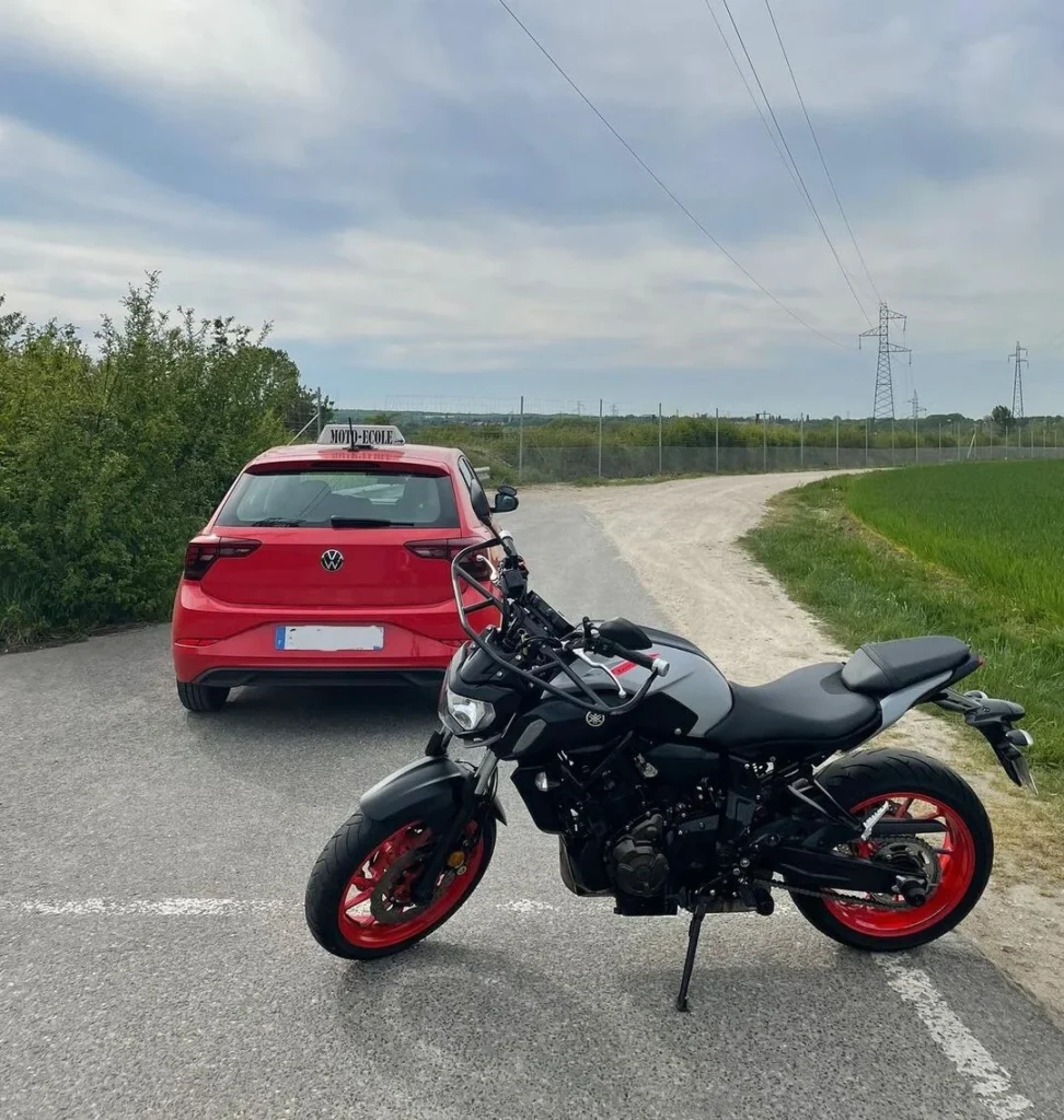 Voiture-école rouge et moto-école garées côte à côte