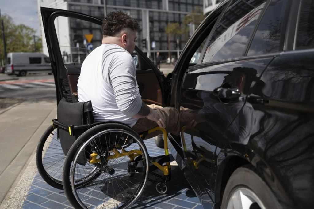 Conducteur en fauteuil roulant montant dans une voiture
